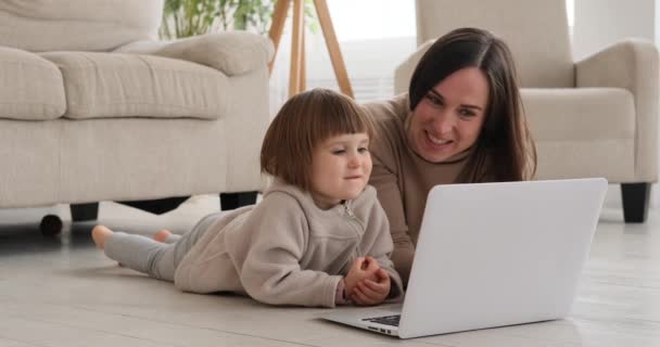 Κορίτσι με μητέρα βλέποντας φορητό υπολογιστή στο σπίτι — Αρχείο Βίντεο
