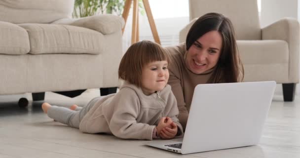 Girl with mother watching laptop at home — Stock Video