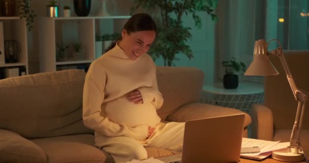 Donna incinta che utilizza il computer portatile di notte — Video Stock