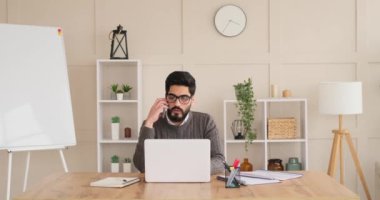 Dizüstü bilgisayar kullanırken cep telefonda konuşurken işadamı