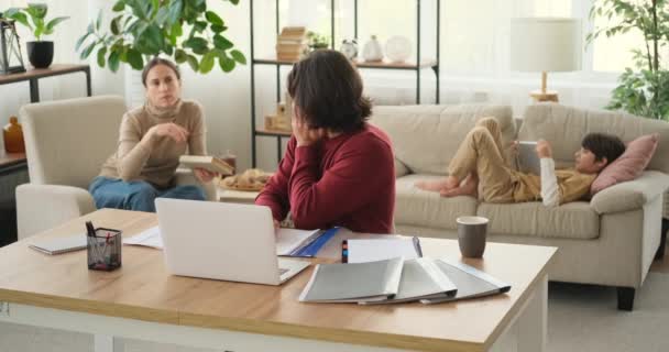 Mother and son disturbing man working from home — Stock Video