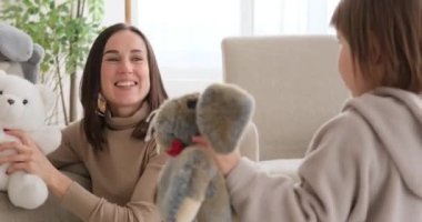 Anne ve kızı yumuşak oyuncaklarla oynuyorlar.