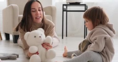 Anne ve kızı yumuşak oyuncaklarla oynuyorlar.