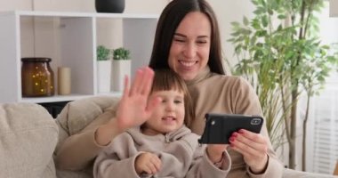 Annesi cep telefonu kullanarak görüntülü konuşma yapan bir kız