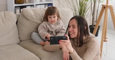 Annesi cep telefonu kullanarak görüntülü konuşma yapan bir kız