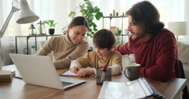 Ebeveynler, oğullarına ödevlerini yapıyor.