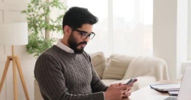 Düşünceli iş adamı cep telefonundan mesaj atıyor.