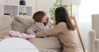 Anne ve kız el kuklası yumuşak oyuncaklarla oynuyorlar.