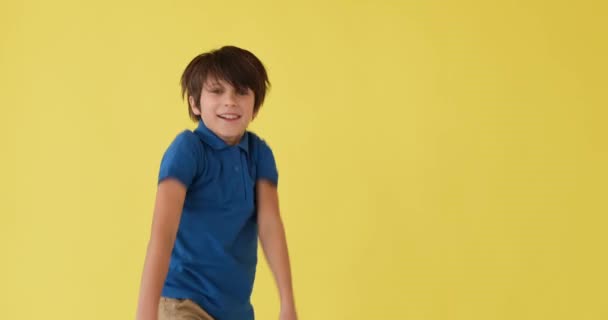 Хлопчик танцює над жовтим тлом — стокове відео