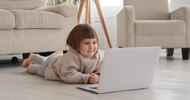 Nettes Mädchen guckt Film auf Laptop zu Hause — Stockvideo
