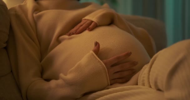 Hamile bir kadın evde karnını okşuyor. — Stok video