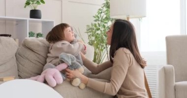 Anne ve kız el kuklası yumuşak oyuncaklarla oynuyorlar.