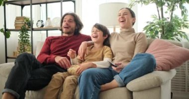 Aile patlamış mısır yiyor ve TV 'de film izliyor.