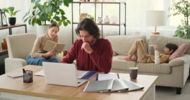 Çalışan anne ve baba kanepeye uzanmış dijital tablet kullanarak oğluyla tartışıyor.