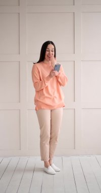 Kadın cep telefonu kullanarak eğlenceli mesajlar alıyor