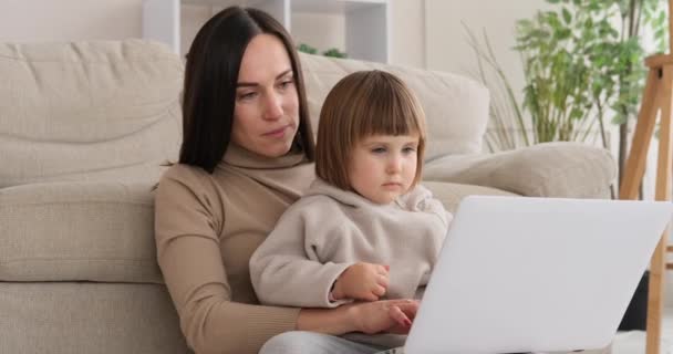 Kızı annesiyle oturuyor ve dizüstü bilgisayarla uğraşıyor. — Stok video