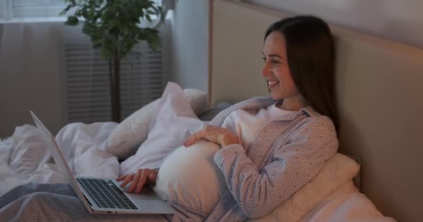 Pregnant woman using laptop at home — Stock Video