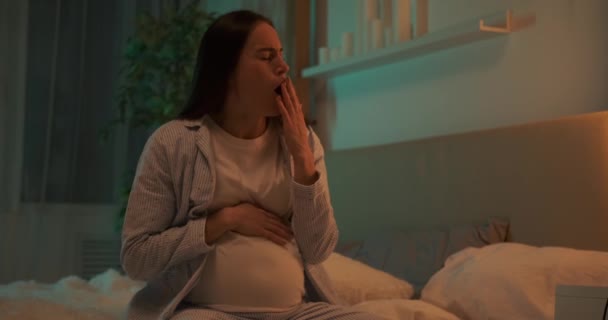 Mulher grávida bocejando na cama à noite — Vídeo de Stock