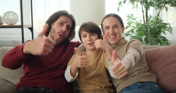 Glückliche Familie gibt Daumen hoch auf dem Sofa — Stockvideo