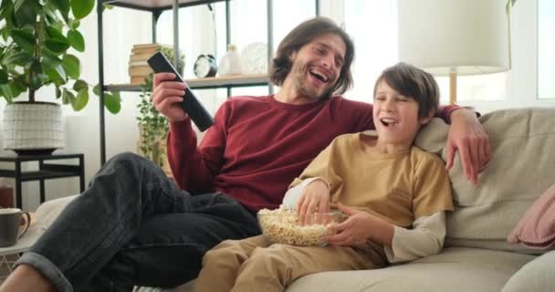 Pai e filho assistindo filme na TV em casa — Vídeo de Stock