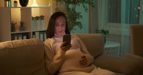 Έγκυος γυναίκα που χρησιμοποιεί κινητό τηλέφωνο τη νύχτα — Αρχείο Βίντεο