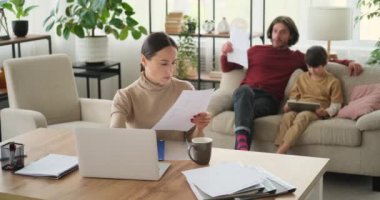 Anne evden çalışırken baba ve oğul dijital tablet kullanıyor.