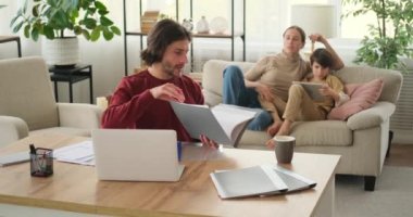 Kadın kocasına evde ve oğullarında dijital tablet kullanarak yardım ediyor. 