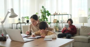 Annesi ödev yapıyor, babası dijital tablet kullanıyor.