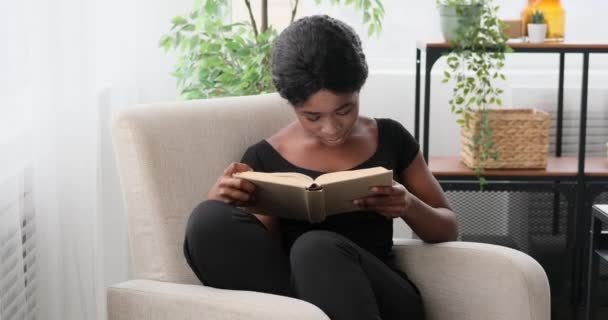 Frau liest zu Hause ein Buch — Stockvideo