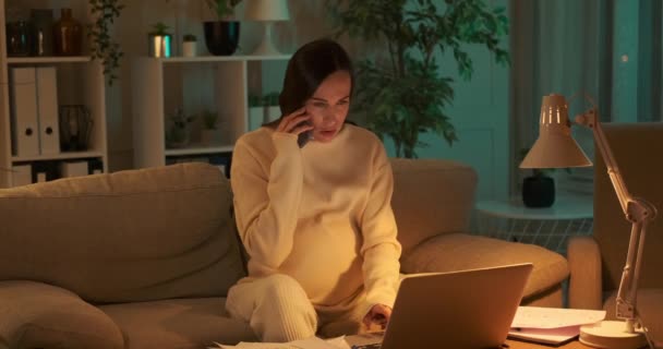 Pregnant woman relaxing on sofa after successfully finishing work late night at home — Stock Video