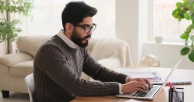 Dizüstü bilgisayarda yazan ve belgeyi analiz eden işadamı