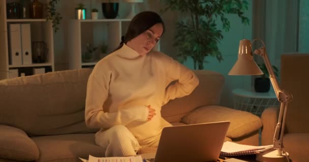 Mujer embarazada trabajando hasta tarde por la noche en la oficina en casa — Vídeos de Stock