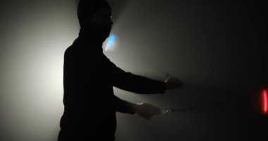Kar maskeli genç adam el aksesuarlarını çeviriyor.