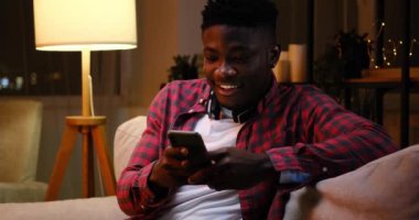 Mutlu Afrikalı Amerikalı adam gece geç saatlerde cep telefonu kullanıyor.