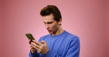 Genç adam cep telefonu kullanırken eğleniyor