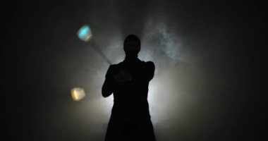 Kar maskeli bir adam el aksesuarları çeviriyor.