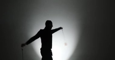 Maskeli genç adamın silueti poi el aksesuarları çeviriyor.