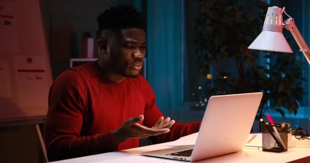 Uomo d'affari afroamericano che utilizza il computer portatile per videoconferenza a tarda notte — Video Stock