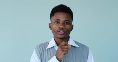 Afrikalı Amerikalı adam dudaklarında parmaklarıyla hareket ediyor.