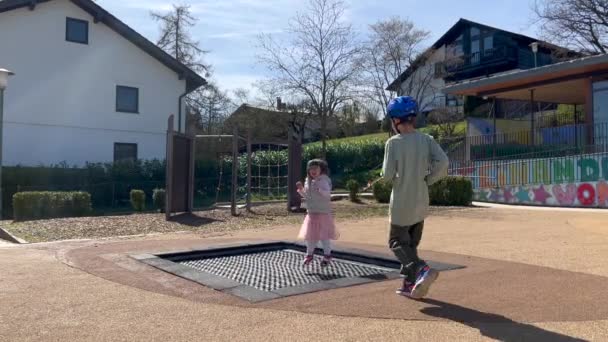 Діти розважаються стрибаючи на батуті — стокове відео