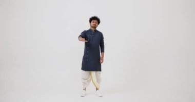 Unhappy Indian man in traditional clothing giving thumbs down gesture