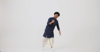 Cheerful Indian man in traditional clothing celebrating victory 