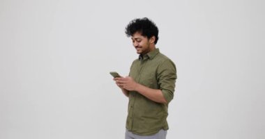 Mutlu genç adam cep telefonunda sohbet ediyor.