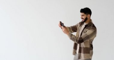 Excited young man playing game on mobile phone