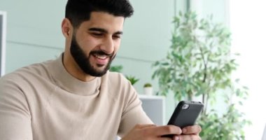 Happy man messaging using mobile phone