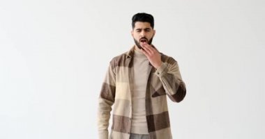 Yorgun genç adam kollarını açmış esniyor.