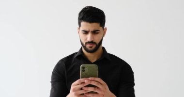 Düşünceli iş adamı cep telefonundan mesaj atıyor.