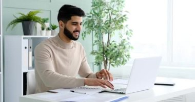 Ofiste dizüstü bilgisayarda daktilo kullanan bir işadamı.