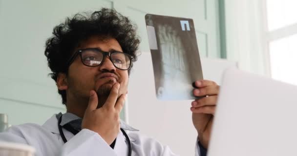 Доктор вивчає рентгенівський звіт в офісі — стокове відео
