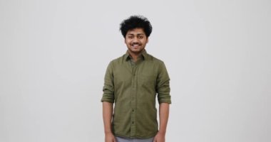 Mutlu genç adam gülümsüyor ve başını sallıyor